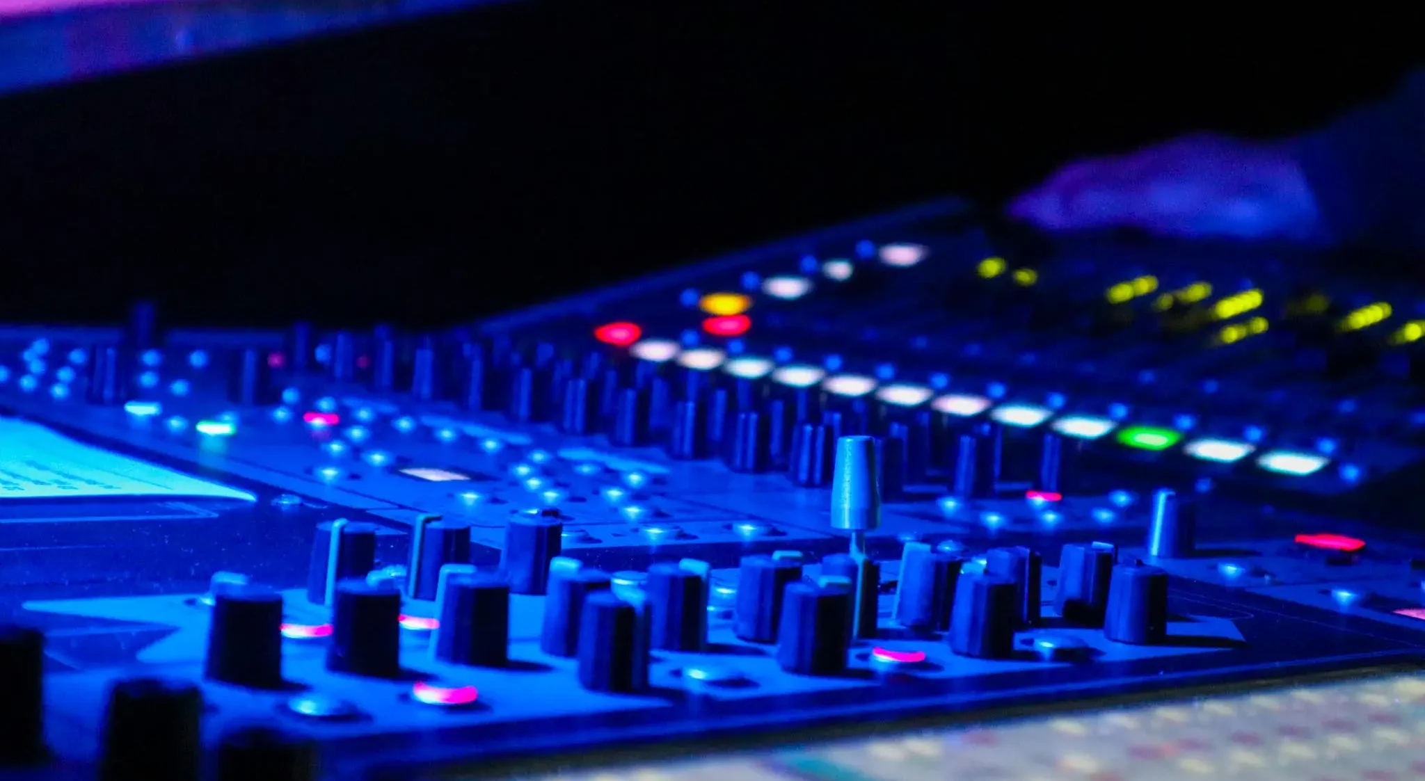 Geluidmixingpaneel met een blauwe gloed aan licht